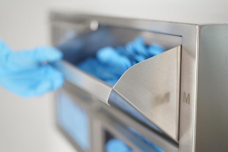 Geöffnetes Metallfach worin blaue Reinraumhandschuhe liegen. By Immagine Werbeagentur München
